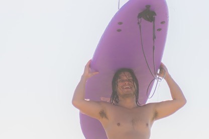 Dustin surfing on a wave